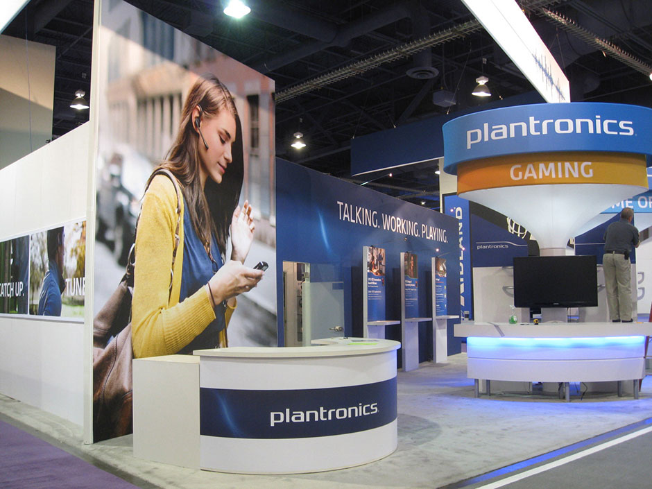 Booth front with registration desk, demo stations, and hero kiosks.